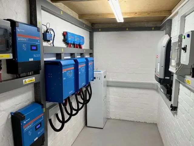 Plant room with wall-mounted inverters, charge controllers and a lithium battery cabinet